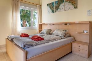 Una cama con dos toallas rojas en una habitación en Villa Vista Almuñécar, en Granada