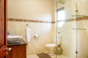 a bathroom with a toilet and a glass shower at Sondela Nature Reserve & Spa Makhato Lodges in Bela-Bela