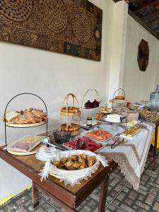 a table with many different types of bread and pastries at Pousada Recanto das Orquídeas in Barreirinhas