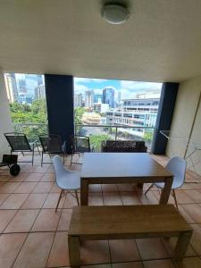 a room with a table and chairs and a view of a city at Large studio balcony, spa & pool in Brisbane