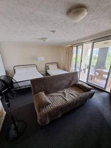 a living room with two beds and a couch at Large studio balcony, spa & pool in Brisbane