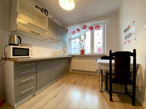 a kitchen with a table and a microwave and a table sidx sidx sidx at Hostel szopena lotnisko in Warsaw