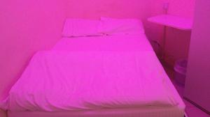 a pink bedroom with two beds in a room at Ruby Star Couples Hostel G P 1&2 in Dubai
