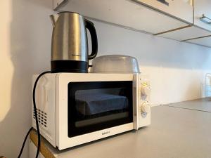 a blender sitting on top of a microwave at Hostel szopena lotnisko in Warsaw