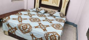 Bett mit einer goldenen und weißen Bettdecke und Kissen in der Unterkunft Maa durga guest house in Ghāzīpur