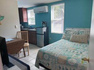 a bedroom with a bed and a desk and a kitchen at Pine View Lodge Old Orchard Beach in Old Orchard Beach