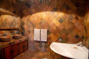 a bathroom with a tub and a sink at Sondela Nature Reserve & Spa Makhato Lodges in Bela-Bela