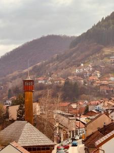 a city with a clock tower in the middle of a town at Jelly Apartment in Visoko