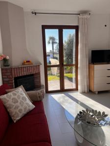 een woonkamer met een rode bank en een glazen tafel bij Terrassen Wohnung Bacio del Sole in Maccagno Inferiore
