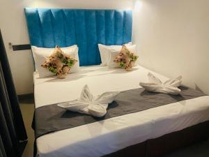 Una cama con almohadas blancas con arcos. en Hotel Gimanhala Thisawewa, en Anuradhapura