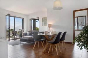 een woonkamer met een tafel en stoelen en een bank bij Terrassen Wohnung Bacio del Sole in Maccagno Inferiore