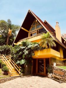 uma casa amarela com uma escada em frente em Pousada Do Chalé em Bento Gonçalves