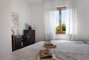 a bedroom with a bed with two towels on it at Terrassen Wohnung Bacio del Sole in Maccagno Inferiore