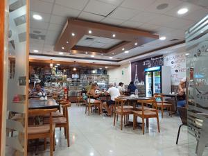 a restaurant with people sitting at tables in it at Arena Hostal in Paracas