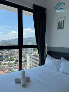 a bedroom with a bed with a large window at Urban Suites @ George Town Penang by BNB4U in George Town