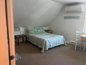a small bedroom with a bed and a table at Pine View Lodge Old Orchard Beach in Old Orchard Beach