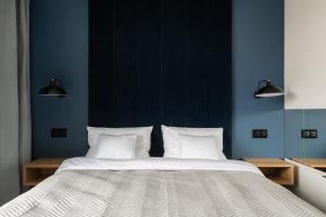 a bedroom with a large bed with blue walls at AVAPATRS Apartament BLUE in Jastarnia