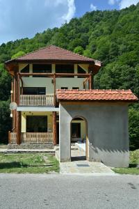 a house with a porch and a balcony at Pensiunea Tihna in Rîu de Mori