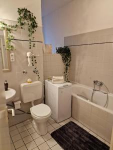 ein Badezimmer mit einem WC, einer Badewanne und einem Waschbecken in der Unterkunft Appartement Berlin Charlottenburg in Berlin