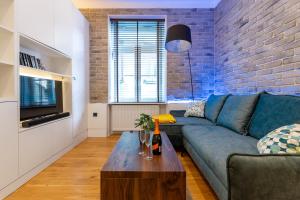 a living room with a blue couch and a coffee table at Apartament Na Deptaku in Lublin