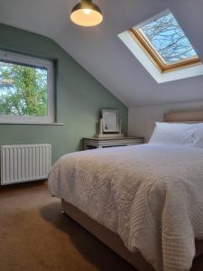 a bedroom with a bed and a window at Sullatober House with hot tub and games room in Carrickfergus