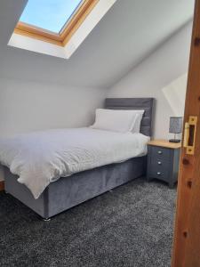 1 dormitorio con cama, escritorio y ventana en Sullatober House with hot tub and games room, en Carrickfergus