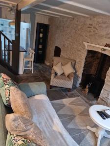 a living room with a couch and a fireplace at Little Cottage, Big Character in Pontypridd