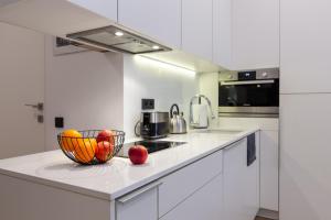 a white kitchen with a bowl of fruit on a counter at Apartament Na Deptaku in Lublin