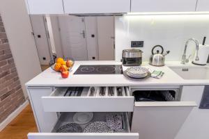 a white kitchen with a stove and a sink at Apartament Na Deptaku in Lublin
