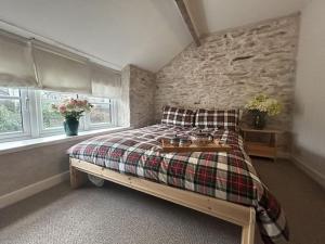 a bedroom with a bed and a stone wall at Little Cottage, Big Character in Pontypridd