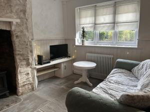 a living room with a couch and a television at Little Cottage, Big Character in Pontypridd