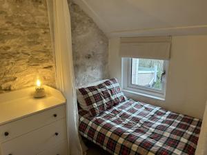 a small bedroom with a bed and a window at Little Cottage, Big Character in Pontypridd