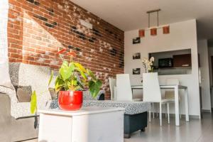 een kamer met een bakstenen muur en een tafel en stoelen bij Casa Rural Viña Vella in Esteiro
