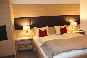 ホルツガウにあるGästehaus Auerのベッドルーム1室(大型ベッド1台、赤い枕付)