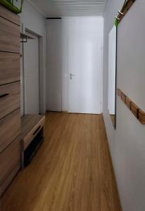 an empty room with a wooden floor and white walls at Grimming view Apartment in Tauplitz