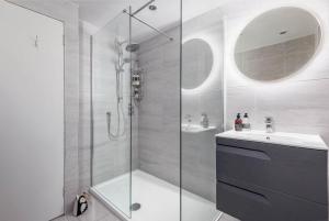 a bathroom with a shower and a sink and a mirror at Gibson Place - 15 Secs to The Old Course: Parking Nearby in St Andrews