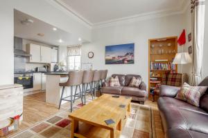 a living room with a couch and a table at Gibson Place - 15 Secs to The Old Course: Parking Nearby in St Andrews