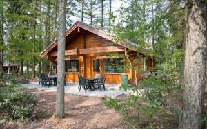 eine Blockhütte mit Tischen und Stühlen im Wald in der Unterkunft Finse bungalow max 5 volwassenen + 3 kinderen in Otterlo