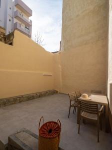 eine Terrasse mit Stühlen, einem Tisch und einer Wand in der Unterkunft Casa Del Centro Storico,By IdealStay Experience in Iraklio