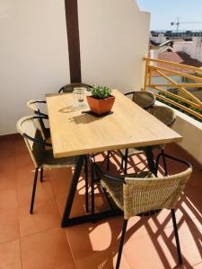 een houten tafel met stoelen en een potplant erop bij Appartement Casa Lina Lagos vue mer in Lagos