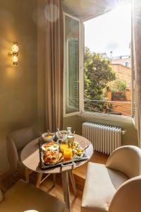 - une table avec un plateau de nourriture devant une fenêtre dans l'établissement Residenza Pierret, à Rome