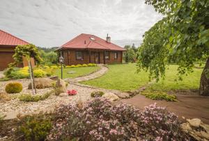 una casa con un jardín delante de ella en Dom pod Wiankami en Korczyna