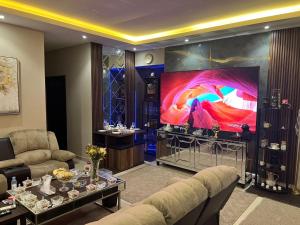 una sala de estar con una pantalla grande en una habitación en كمباوند السليمانية en Riad