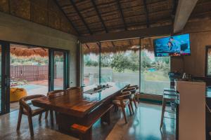 a dining room with a large wooden table and chairs at Shalmari's Hut in South Tambo