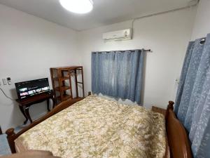 - une chambre avec un lit et une télévision dans l'établissement บ้านโรสแมรี่ By ชมภู ชุมแพ โฮมสเตย์ ไร่คุณต๋ง, 
