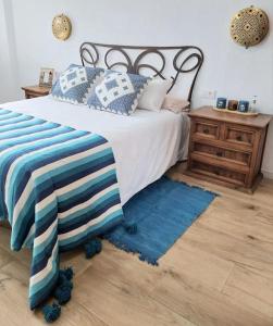 1 dormitorio con 1 cama con almohadas azules y blancas en Apartamento Thematic OyM, en Villena