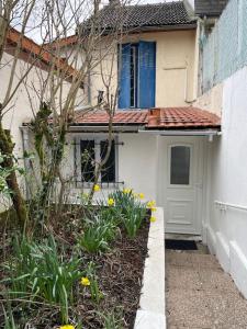 uma casa com uma porta e flores à frente dela em Maison indépendante 7 minutes RER B em Antony