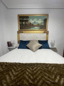 1 dormitorio con 1 cama con una pintura en la pared en Apartamento Thematic OyM, en Villena
