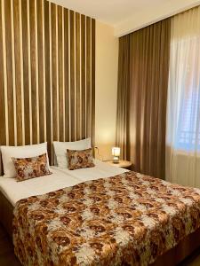 a bedroom with a large bed and a window at Kera Rooms in Tʼelavi