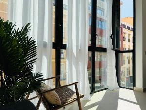 una silla sentada frente a una gran ventana en Victoria Beach Premium, en Málaga